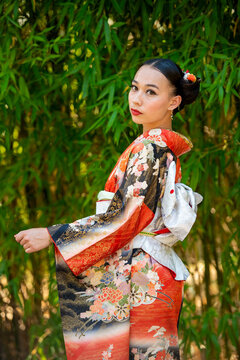 Portrait of woman wearing kimono standing in park