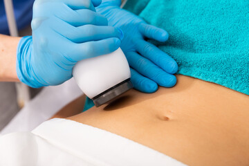 Obraz na płótnie Canvas Closeup of female abdomen during ultrasonic fat cavitation procedure at aesthetic clinic
