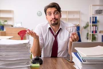 Young male employee and too much work in the office