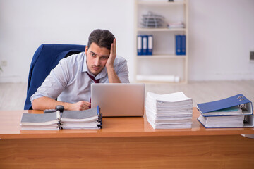 Young businessman and too much work in the office