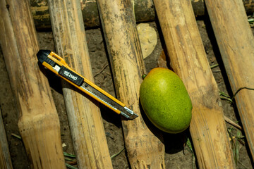 Mango ready to cut with knife on bamboo it's a versatile food