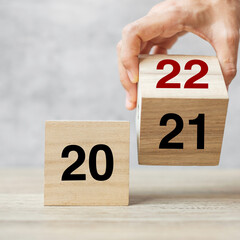 hand flipping block 2021 to 2022 text on table. Resolution, strategy, plan, goal, motivation,...