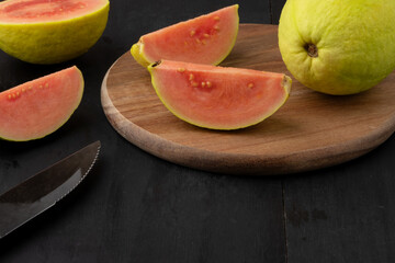 Fototapeta na wymiar Whole and halves of ripe red guava.