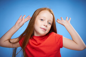 Fototapeta premium cheerful cute red-haired girl childhood blue background