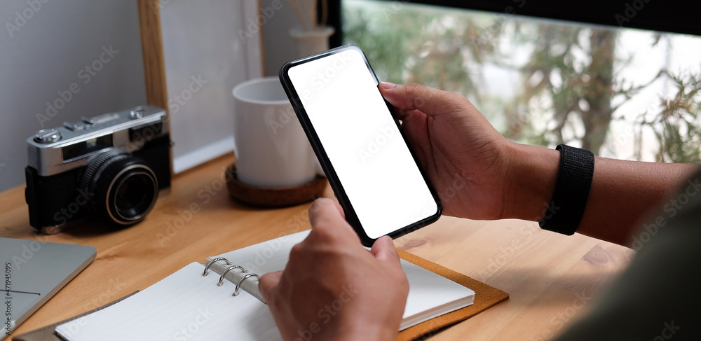 Poster close up view man holding mock up smart phone with white screen...