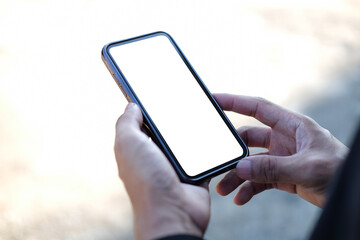 Close up view man holding mock up mobile phone with blank screen..