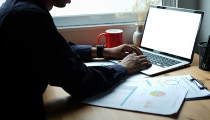Cropped shot young man working with computer laptop at home office.