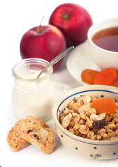 Healthy breakfast. Bowl of yogurt with granola, dried apricots and apples