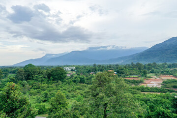 Scenic aerial view of the forest against mountain range in cloudy sky