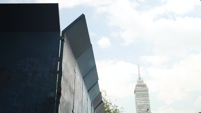 Blue barriers and barricades are erected in Mexico City ahead of public march and protest by local activists. Mirador Torre Latino in background