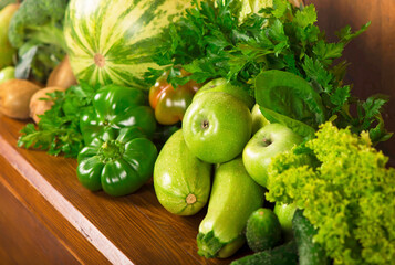 Useful green vegetables on a wooden background.