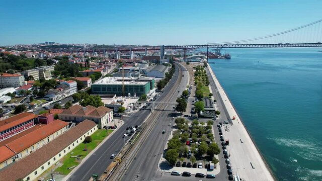 Aerial drone view of a train and traffic on road N6, in sunny Lisbon, Portugal
