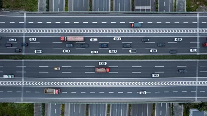 Foto op Aluminium Top down aerial view from drone on modern traffic junction of multiple lane highway road in metropolis city. Heavy traffic on motorways. Elevated curved roads, clover shape bridge with no speed limit. © D. Kvasnetskyy