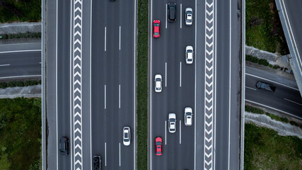 Top down aerial view from drone on modern traffic junction of multiple lane highway road in metropolis city. Heavy traffic on motorways. Elevated curved roads, clover shape bridge with no speed limit.