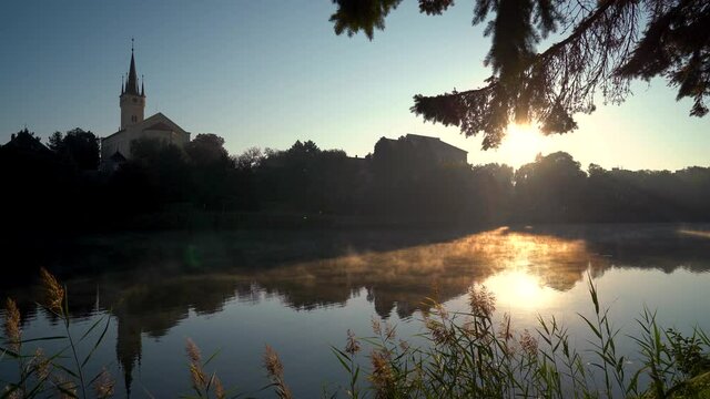czech city Caslav seen over a steaming pond in the morning sun, static