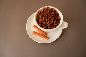Coffee beans, Cinnamons and cup and saucer on brawn background. Cafe, Coffee, restaurant design elements.