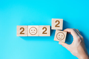 hand holding Smile face block with 2022 text on blue background. Satisfaction, feedback, Review and...