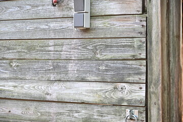 verwitterte Wand aus Holz mit Steckdosen als Hintergrund
