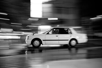 Fototapeta na wymiar Taxi driving fast in the city at night