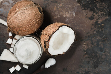 Coconut oil and fresh coconuts on an old metal background. Organic spa oil. Layout with copy space