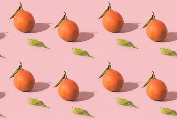 Fruit seamless pattern of fresh tangerine, clementine with green leaf on pink background with hard shadows. Citrus in minimal style.