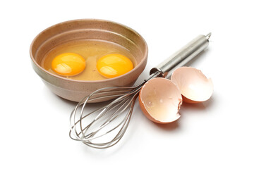 Wire whisk and brown eggs on white background 