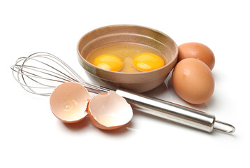 Wire whisk and brown eggs on white background 