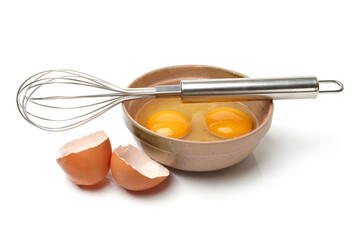 Wire whisk and brown eggs on white background 