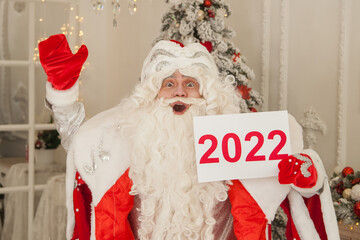 Russian Santa Claus - Grandfather Frost in New Year's decoration holds a white sign with the year 2022