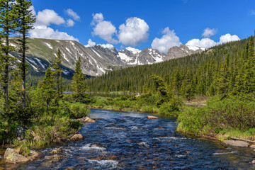 Fototapeta na wymiar Spring Mountain Creek - South Saint Vrain Creek at Long Lake, with Indian Peaks towering in background, on a sunny Spring morning. Indian Peaks Wilderness, Colorado, USA.