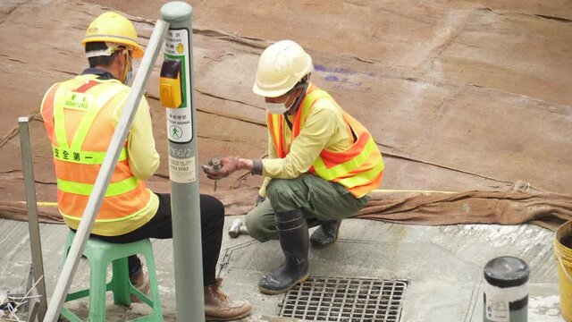 Road construction workers discussing on a road construction site in Hong Kong