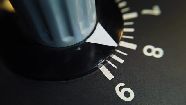 Detail shot. Rotating the variable resistor knob on old equipment on a scale of 9.