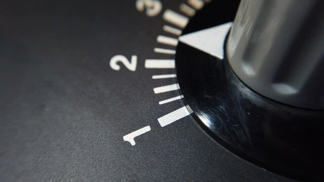 Detail shot. Turning the variable resistor knob on old equipment, from scale 1 to scale 3 and back.