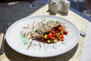 Neats tongue fried with vegetables, greens and mushroom sauce
