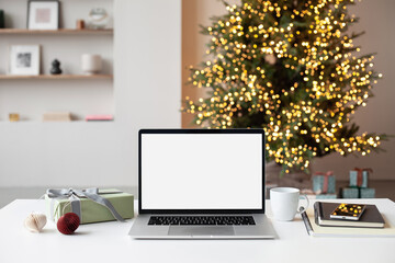 Beautiful Christmas workplace, laptop computer with blank white mockup screen. Online shopping during winter holiday, ordering xmas gifts concept. Website template 