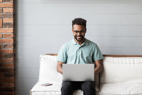 Young Man Using Laptop Computer At Home. Student Men Working Or Learning Online In His Room. Work Or Study From Home, Freelance, Modern Lifestyle Concept.