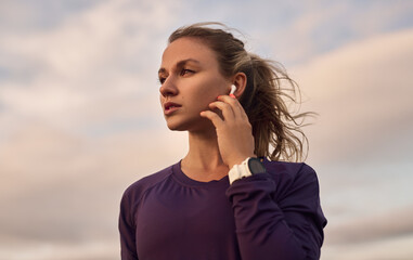 Young woman listening to music in earbuds