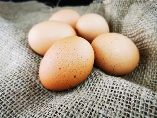 Brown eggs on a piece of jute. Fresh brown cage free eggs on burlap. 