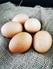 Brown eggs on a piece of jute. Fresh brown cage free eggs on burlap. 