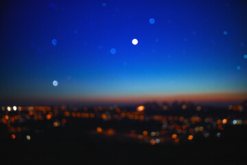 Out of focus landscape with bokeh star and distant city streetlights.