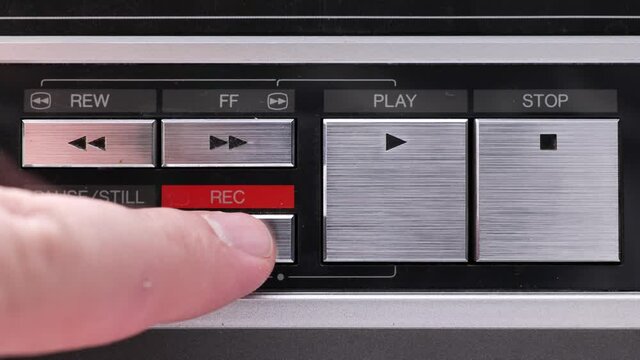 Extreme close up of buttons on an old antique or vintage VCR, Pushing and holding the Record button
