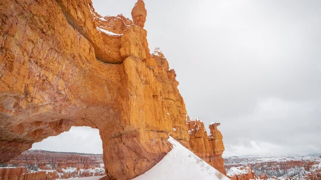 Bryce Canyon National Park Utah USA, Time Lapse of Clouds Moving Above Snow Capped Rock Formations and Natural Arch