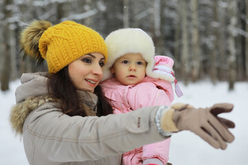Obraz premium Happy family playing and laughing in winter outdoors in the snow. City park winter day.