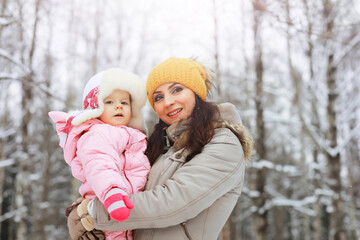 Fototapeta premium Happy family playing and laughing in winter outdoors in the snow. City park winter day.