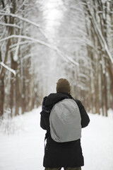 Outdoor portrait of handsome man in coat and scurf. Bearded man in the winter woods.