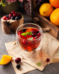 hot tea with berries and lemon in a glass mug on the table. the concept of coziness, autumn and winter mood, Christmas mood, Christmas background, tea ceremony