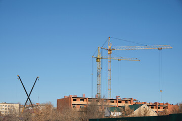 Two high rise cranes and two small ones are involved construction residential building.
