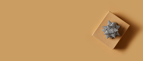 Fathers day concept with craft paper gift and bow on brown background