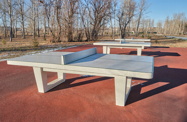 Table tennis tables in autumn public park.