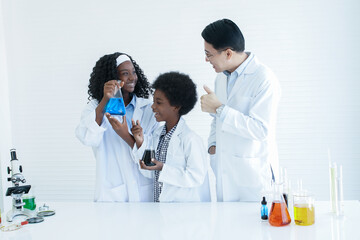 Little African kids studying chemistry and doing chemical science experiment in laboratory at...